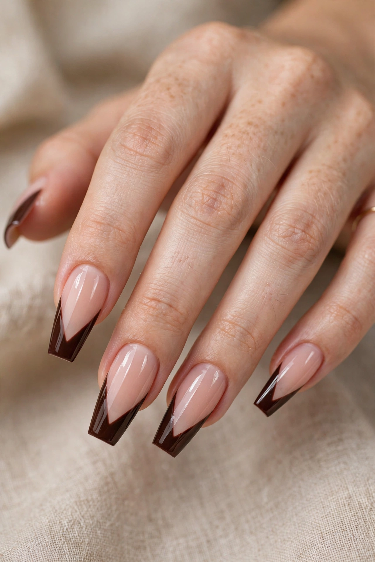 Close-up of coffin nails with sharp V-cut chocolate-brown French tips