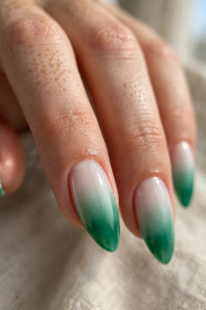 Almond nails with a seamless emerald French fade feathering from a milky white base with no hard smile line.
