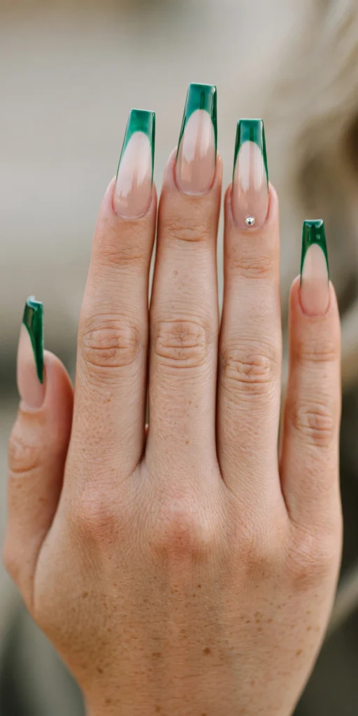 Long coffin nails with glossy emerald French tips and a single crystal rhinestone accent at the base of the ring nail.