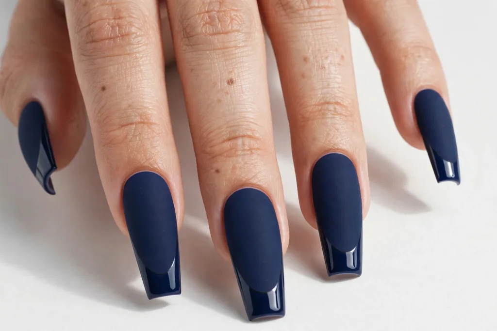 Matte Navy Fourth of July French Tip Nails Matte navy blue nails with glossy navy French tips in the same color for a subtle finish contrast, shown on long coffin nails.
