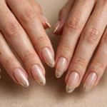 Champagne gold glitter fade French tip nails on almond-shaped nails