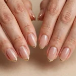 Classic thin gold French tip nails on almond-shaped nails
