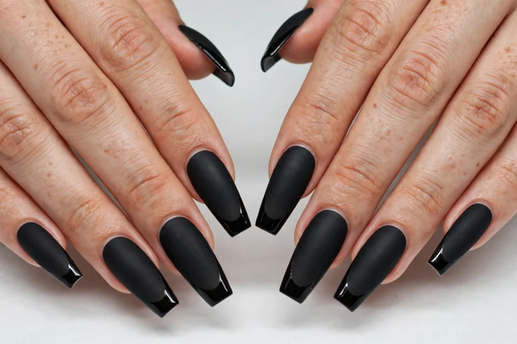 Matte Black Nails with Glossy Halloween French Tips Matte black nails with glossy black French tips in the same color for a subtle finish contrast, shown on long coffin nails.