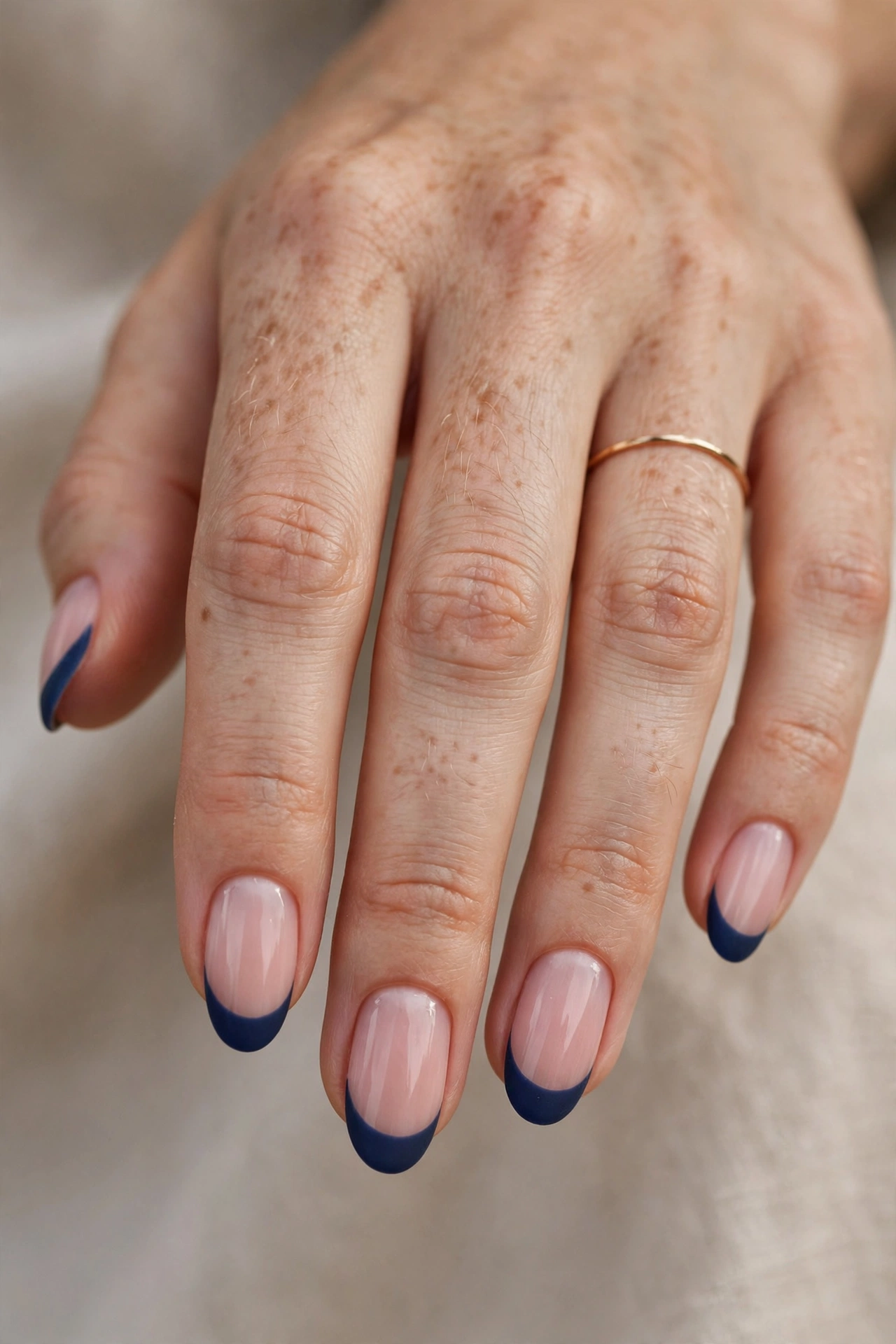 Medium oval nails with velvety matte navy French tips over a sheer blush base.