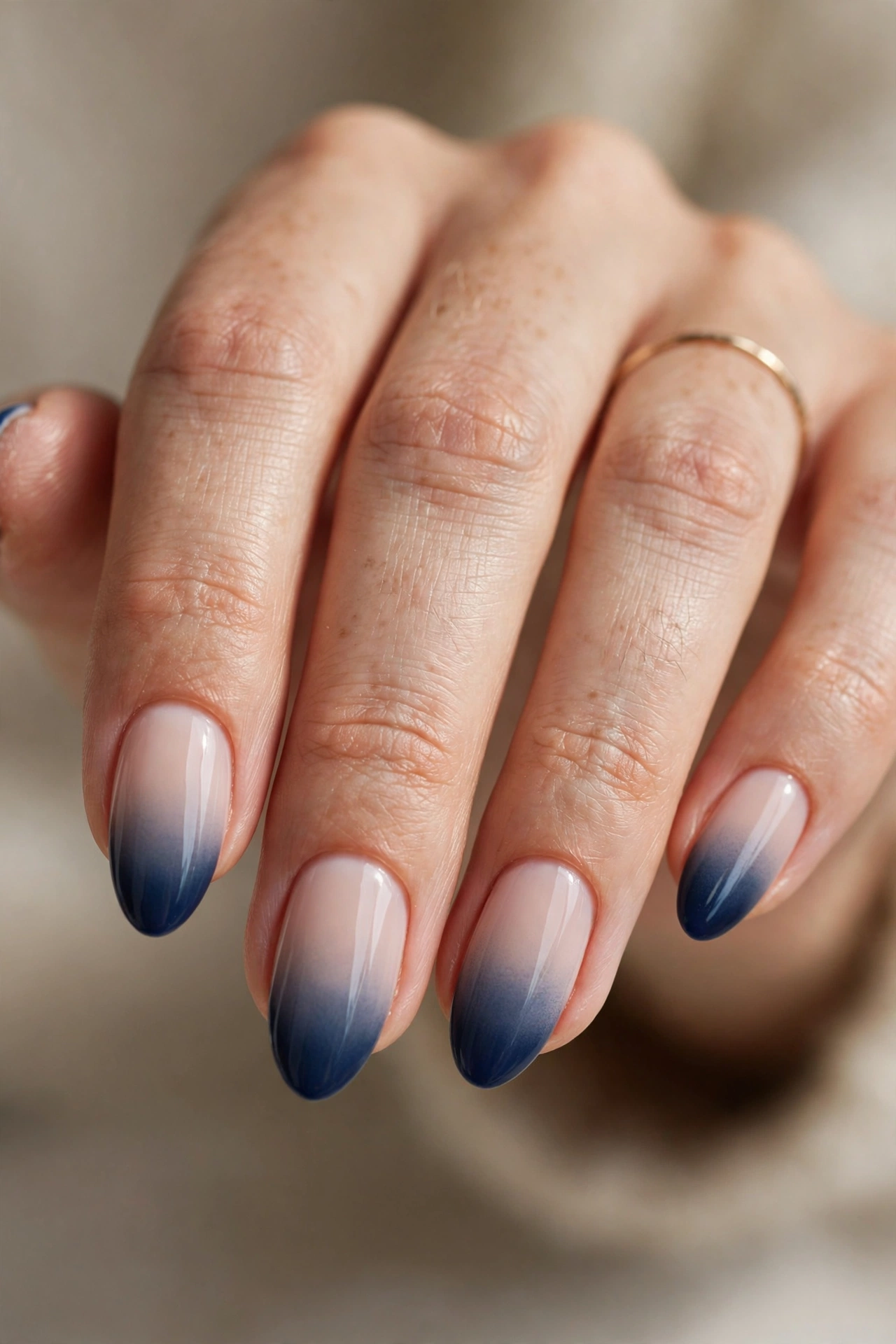 Almond nails with a seamless navy French fade blending from a milky nude base into deep navy at the tips.