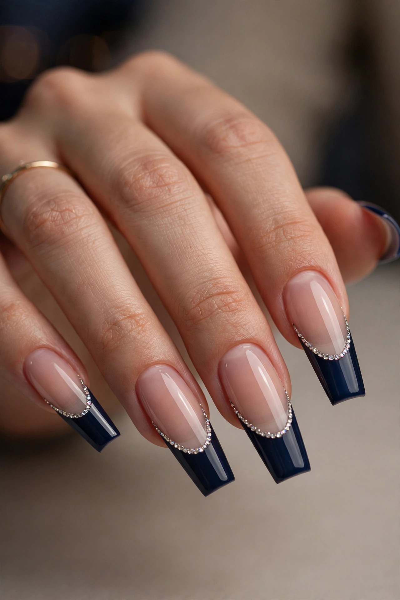 Long coffin nails with navy French tips edged with a line of tiny sparkling crystal rhinestones.